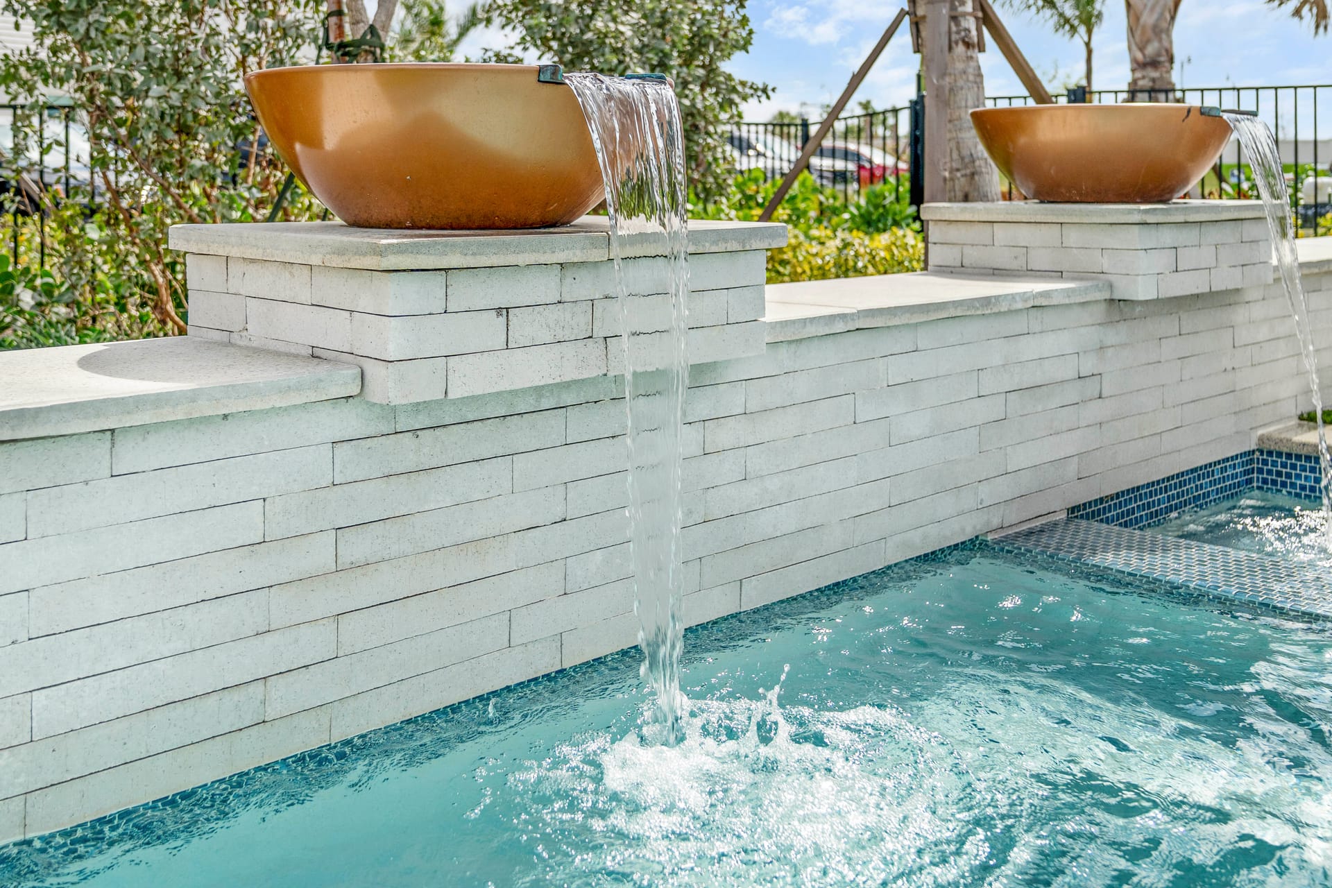 Sheer descent water feature flowing into pool, close-up detail shot