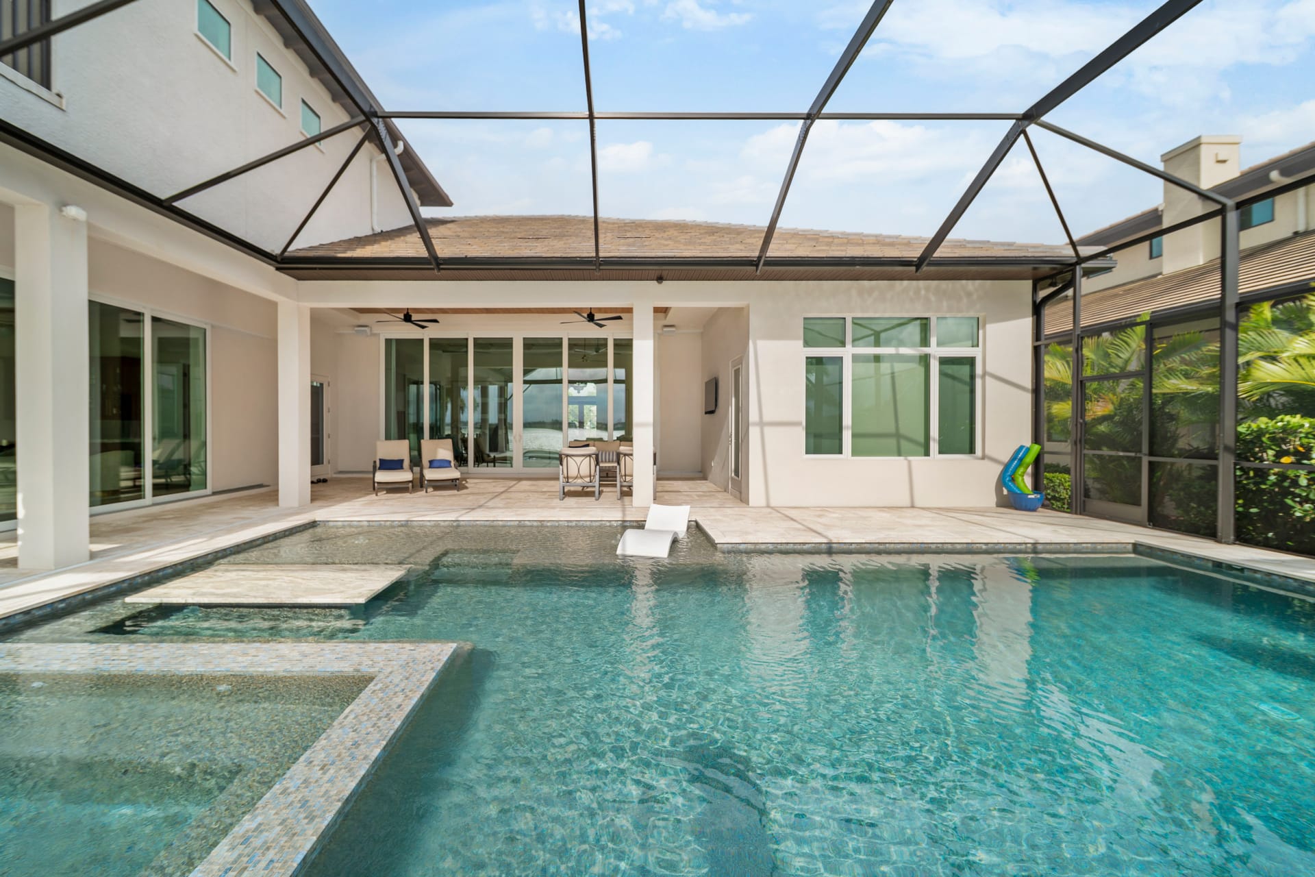 Free-form pool with natural stone coping and lush tropical landscaping at golden hour - Swim Inc. custom pool Sarasota