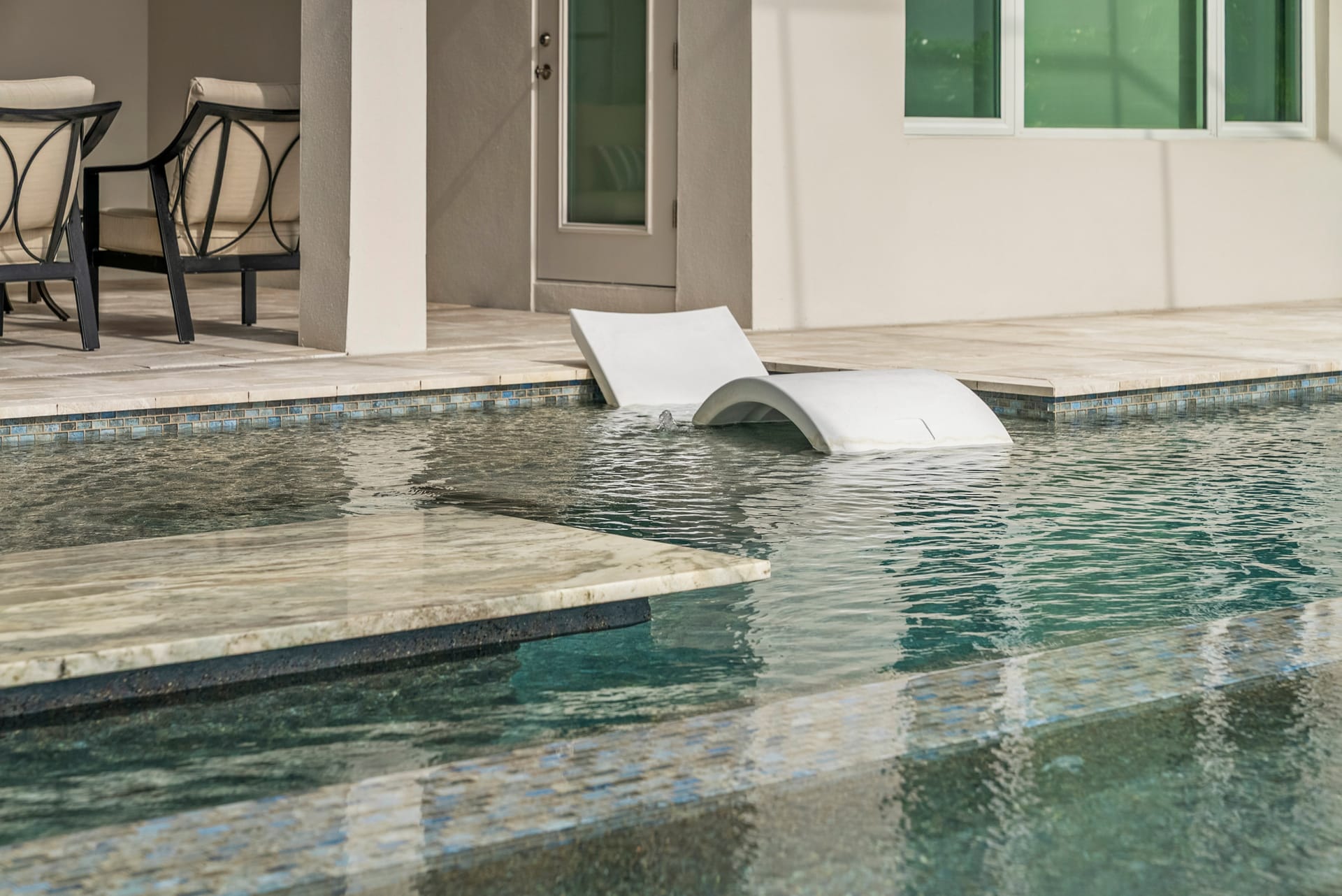 Oversized flush spa at twilight with warm color-changing LED lighting on resort-style pool, Sarasota, FL, Swim Inc.